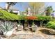 Backyard with a stone patio, seating under an orange umbrella, and lush greenery at 902 Lenox Hill Ne Ct, Atlanta, GA 30324