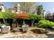 A beautiful backyard featuring stone patio, seating, lush greenery, and an orange umbrella at 902 Lenox Hill Ne Ct, Atlanta, GA 30324