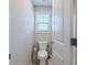 Powder room showcasing a toilet, toilet paper holder, and white-painted doors at 113 Cottage Walk, Cartersville, GA 30121