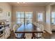 Light-filled dining room featuring a large wooden table, chair seating, and a view of the backyard at 113 Cottage Walk, Cartersville, GA 30121