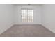 Bedroom featuring a neutral carpet, light grey walls, and a large window at 334 Royal Crescent Way, Stockbridge, GA 30281