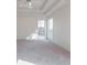 Bright bedroom with carpet floors, a tray ceiling with ceiling fan, and two sunny windows at 334 Royal Crescent Way, Stockbridge, GA 30281