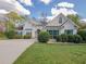 Charming one-story home with stucco exterior, green shutters, well-manicured landscaping, and concrete driveway at 334 Royal Crescent Way, Stockbridge, GA 30281