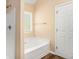 Bright bathroom with a tub, white cabinets, and neutral walls at 45 Chapman Way, Covington, GA 30016