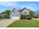 Charming two-story home with gray siding, a well-manicured lawn, and a driveway leading to a two-car garage at 45 Chapman Way, Covington, GA 30016