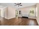 Spacious living room featuring hardwood floors, large windows, a ceiling fan, and a fireplace at 45 Chapman Way, Covington, GA 30016