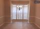 Inviting dining area with an elegant chandelier, wainscoting, and a large window for natural light at 6158 Thorncrest Dr, Tucker, GA 30084