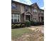 Townhouse exterior with a brick facade, covered porch, and tidy landscaping at 6158 Thorncrest Dr, Tucker, GA 30084