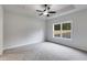 This bedroom features neutral colors, a ceiling fan, and a window with natural light at 1765 Harmony Rd, Temple, GA 30179