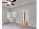 This bedroom features neutral colors, a ceiling fan, and two entrances to a closet and bathroom at 1765 Harmony Rd, Temple, GA 30179