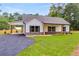 Charming single-story home featuring a light exterior, a stone foundation, and well manicured front yard at 1765 Harmony Rd, Temple, GA 30179