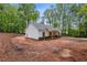 Exterior side view of single story home on large dirt lot and surrounded by trees at 1765 Harmony Rd, Temple, GA 30179