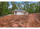 Exterior of new home with wooden porches surrounded by a lush, wooded landscape at 1765 Harmony Rd, Temple, GA 30179