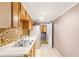 Kitchen with tiled floors, mosaic backsplash, stainless steel sink, and wooden cabinets at 3556 Riley Rd, Douglasville, GA 30134