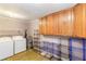 Laundry room with washer, dryer, and ample cabinet and shelving space at 3556 Riley Rd, Douglasville, GA 30134