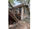 Home exterior with wooden stairs leading to a small deck, set upon a stone foundation in need of repair at 4216 Connor Dr, Ellenwood, GA 30294