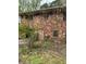 Two-story brick home with multiple windows needing repair, surrounded by overgrown vegetation and debris at 4216 Connor Dr, Ellenwood, GA 30294
