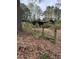 A damaged, one-story brick home, partially obscured by overgrown foliage, and in need of extensive renovation at 4216 Connor Dr, Ellenwood, GA 30294