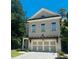 Two-story home featuring a light brick facade and a two-car garage with a pergola above it at 134 Wards Crossing Way # 17, Johns Creek, GA 30022