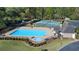 Aerial view of the community pool, tennis courts, and playground in a wooded setting at 169 Twickenham Trce, Suwanee, GA 30024