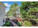 Landscaped backyard with a stone pathway, garden, and mature trees at 169 Twickenham Trce, Suwanee, GA 30024