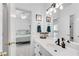 Bright bathroom with white cabinets, sink, and a doorway view into the bedroom at 169 Twickenham Trce, Suwanee, GA 30024