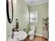 Cozy bathroom featuring a single sink vanity, toilet, and a charming decorative shelving unit at 169 Twickenham Trce, Suwanee, GA 30024