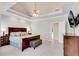 Beautiful main bedroom featuring a tray ceiling, carpet and mounted television for relaxation at 169 Twickenham Trce, Suwanee, GA 30024