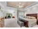 Spacious main bedroom with a tray ceiling, large bed, and a separate sitting area with abundant natural light at 169 Twickenham Trce, Suwanee, GA 30024