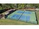 Aerial view of the well-maintained tennis courts surrounded by lush trees at 169 Twickenham Trce, Suwanee, GA 30024