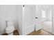 Bathroom featuring a toilet, bathtub with white surround, and view into bedroom at 65 Indian Springs Ne Dr, Rydal, GA 30171