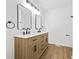 Bathroom featuring dual sinks, a light wood vanity, modern faucets, and framed mirrors at 65 Indian Springs Ne Dr, Rydal, GA 30171