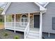 Close-up of the stone front porch with white railings and a gray front door at 65 Indian Springs Ne Dr, Rydal, GA 30171