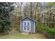 Charming backyard shed with double doors, nestled amongst mature trees and lush greenery at 65 Indian Springs Ne Dr, Rydal, GA 30171