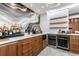 Stylish home bar featuring wood cabinets, marble counters, and a unique backsplash at 9105 Old Southwick Pass, Johns Creek, GA 30022