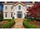 Elegant home entrance with stone steps, manicured bushes, and sophisticated double doors at 9105 Old Southwick Pass, Johns Creek, GA 30022