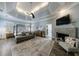 Spacious main bedroom featuring tray ceilings, fireplace, and seating area at 9105 Old Southwick Pass, Johns Creek, GA 30022