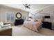 Bright main bedroom featuring large windows, ceiling fan, dresser with mirror, and light pink bedding at 9105 Old Southwick Pass, Johns Creek, GA 30022