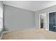 A spacious bedroom with neutral carpet, gray walls, and two doors leading to a closet and bathroom at 4745 Prather Farm Cir, Cumming, GA 30040