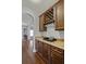 A butler's pantry area with dark wood cabinetry, granite countertops, and a wine rack at 4745 Prather Farm Cir, Cumming, GA 30040