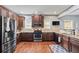 Well-lit kitchen with stainless appliances, dark wood cabinets, and granite countertops at 4745 Prather Farm Cir, Cumming, GA 30040