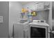 Laundry room with newer model washer and dryer with overhead shelving at 4745 Prather Farm Cir, Cumming, GA 30040