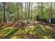 Grassy backyard featuring plenty of mature trees and beautiful surrounding landscaping at 3027 Clove Tree Ln, Woodstock, GA 30189