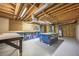 Unfinished basement featuring exposed wood ceiling, concrete walls, and work tables at 3027 Clove Tree Ln, Woodstock, GA 30189