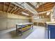 Unfinished basement with exposed wood ceiling, concrete walls, and work tables at 3027 Clove Tree Ln, Woodstock, GA 30189