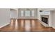 Open living area features gleaming hardwood floors, a fireplace, and natural light, creating a warm and inviting space at 3027 Clove Tree Ln, Woodstock, GA 30189