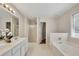 Main bathroom showing double sinks, a soaking tub, and separate shower at 3027 Clove Tree Ln, Woodstock, GA 30189