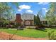 The manicured backyard leads to a brick home with mature landscaping around the home at 423 Morgan Falls Chase, Canton, GA 30114