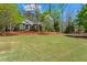 Expansive front lawn featuring a beautiful brick home surrounded by lush, mature trees at 423 Morgan Falls Chase, Canton, GA 30114
