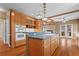 Open kitchen with island, double ovens, hardwood floors, and a view of the living room at 423 Morgan Falls Chase, Canton, GA 30114